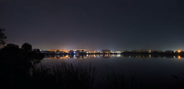 Scenic view of lake against clear sky at night