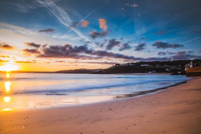 Scenic view of beach against dramatic sky