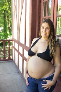 Portrait of smiling woman standing against built structure