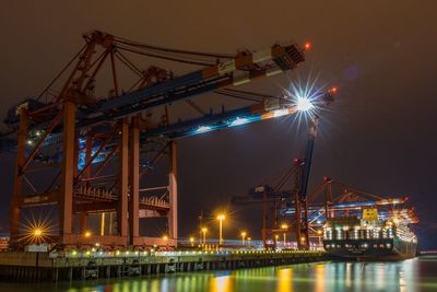 Illuminated commercial dock against sky at night