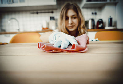Close-up of woman cleaning table