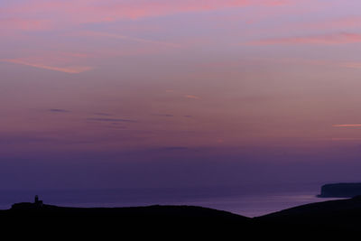 Scenic view of silhouette mountains against romantic sky at sunset