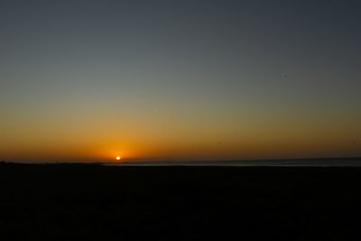 Scenic view of sea against clear sky during sunset