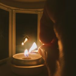 Close-up of lit candle in dark room