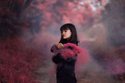 Full length of woman standing against trees during sunset