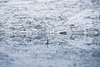 Reflection of person on sea water