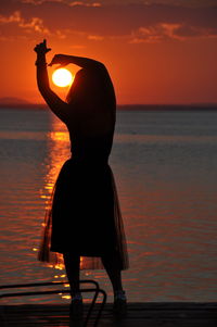 Silhouette woman at beach during sunset