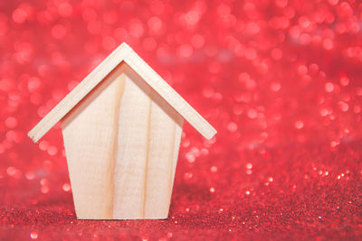 Close-up of birdhouse against red background