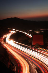 High angle view of light trails on road against sky at night