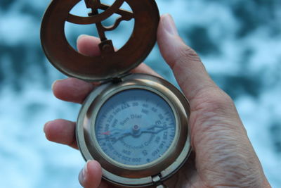 Cropped hand holding pocket watch