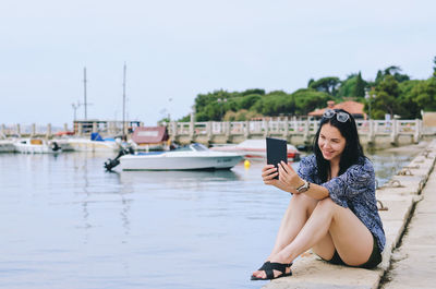 Portrait of young woman sitting on water