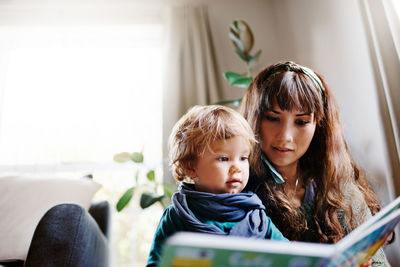 Portrait of mother and daughter sitting at home