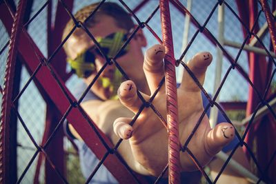 Close-up man hand on chainlink fence