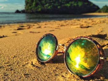 Close-up of sunglasses on beach