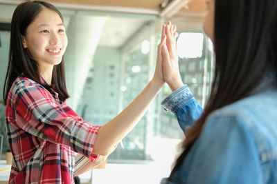 Portrait of smiling woman standing in corridor