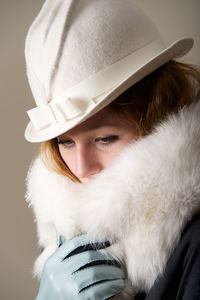 Close-up of young woman looking away against wall