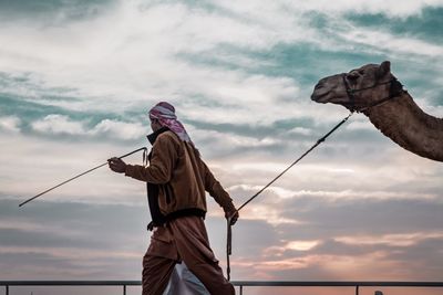 Low angle view of man fishing against sky