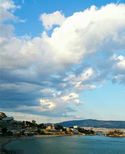 Scenic view of sea by town against sky