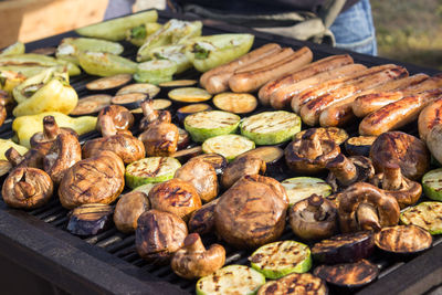 Assorted delicious grilled meats with vegetables over the barbecue on the charcoal. 