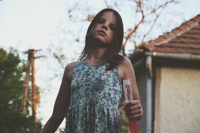 Low angle view of girl standing against sky