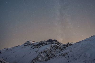 Scenic view of snowcapped mountains against sky at night