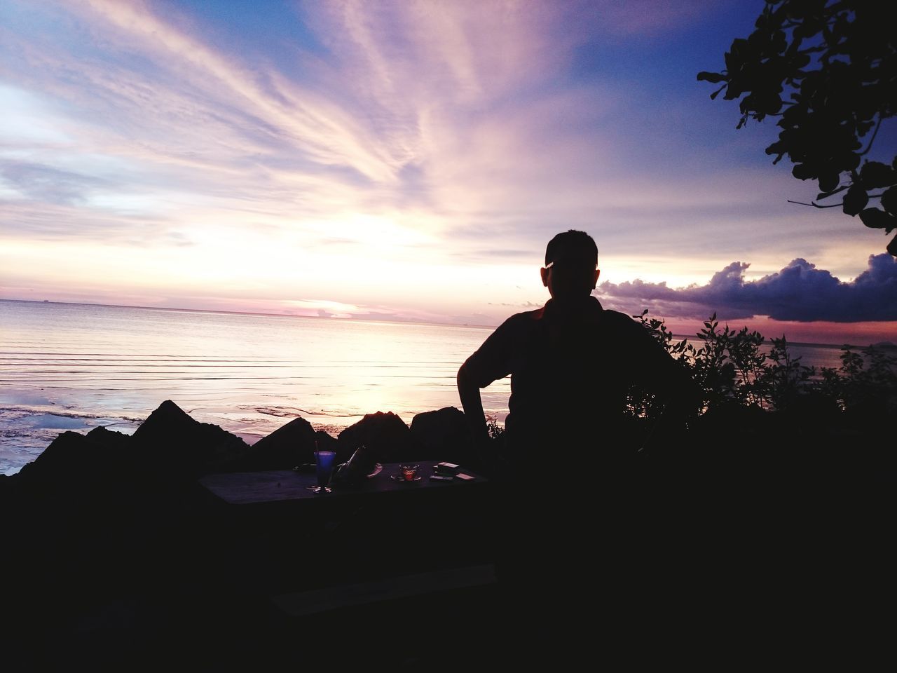 sky, silhouette, sunset, sea, water, one person, nature, cloud, horizon, beach, beauty in nature, land, men, adult, dusk, scenics - nature, leisure activity, relaxation, evening, lifestyles, tranquility, sitting, sunlight, tranquil scene, outdoors, vacation, trip, holiday, backlighting, idyllic