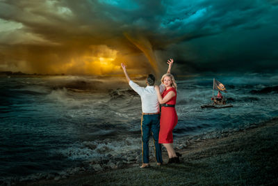 People standing at beach against sky