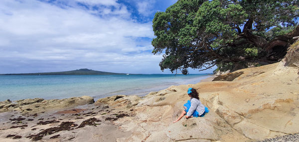 Rear view of man on beach against sky