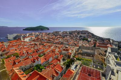 High angle view of townscape by sea against sky