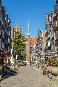 Street amidst buildings in city against clear sky
