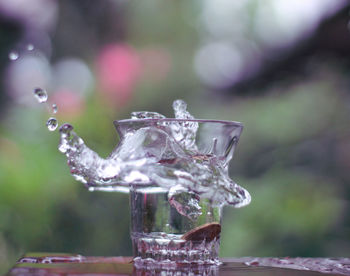 Close-up of glass of water splashing on table
