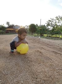 Cute boy on field against sky