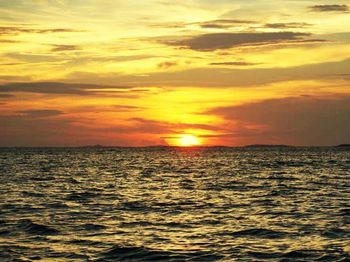 Scenic view of sea against dramatic sky during sunset