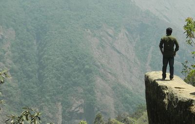 Rear view of man standing on rock