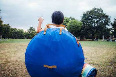 Rear view of woman on field against sky