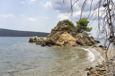 Rocks on sea shore against sky