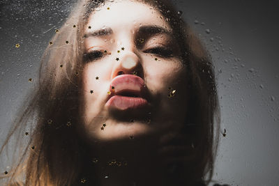 Close-up of woman kissing wet glass with star shape decoration