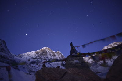 Low angle view of statue against clear blue sky at night