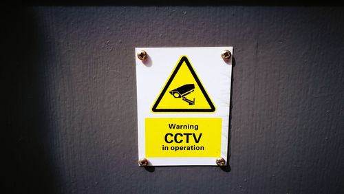 Close-up of yellow sign on wall