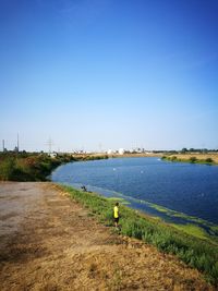 Scenic view of river against clear blue sky