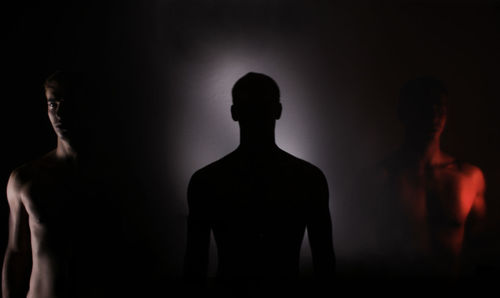 Multiple image of man standing in darkroom