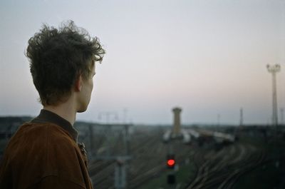 Close-up of man with arms raised against sky