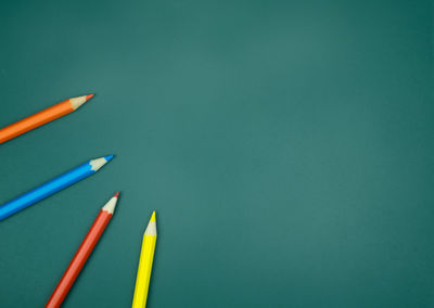 Close-up of colored pencils against blue background