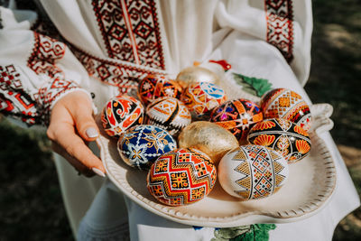 Midsection of woman holding easter eggs in plate