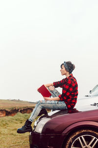 Thoughtful casual woman with book at seashore