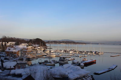 Boats moored in lake against clear sky