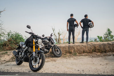Rear view of man riding motorcycle on road