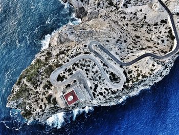 Aerial view of winding road on rock by sea