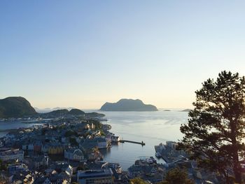 High angle view of city by sea against clear sky