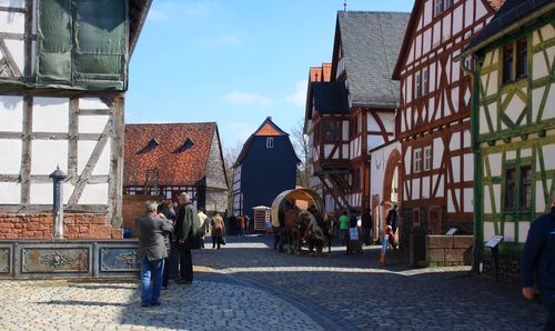 People walking on street amidst buildings in city